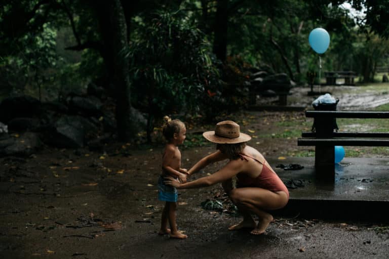 Hawaii travel advisor and blogger, Florabeth Coble fixing her son's shorts, barefoot in Iao Valley, Maui, Hawaii.