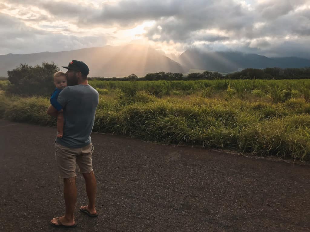 Dad holding baby in front of the West Maui Mountains in Maui, Hawaii.