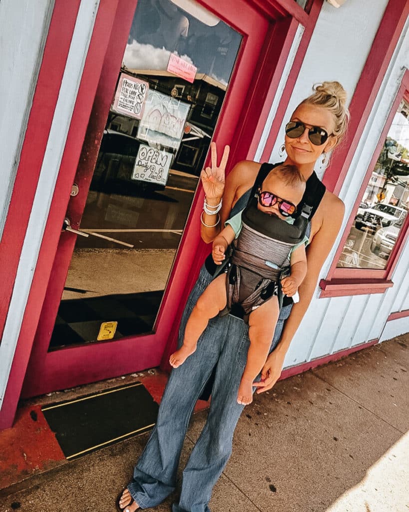 A mom wearing a baby with sunglasses in Paia, Maui.