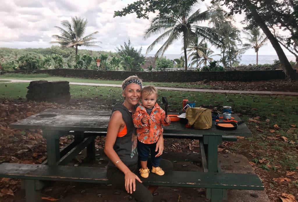 Mom sitting at a picnic table with a toddler at Wainapanapa State Park in Maui, Hawaii.