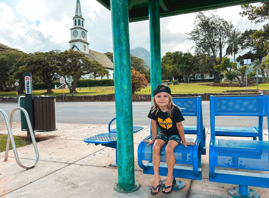 A kid waiting at a bus stop in Maui, Hawaii.