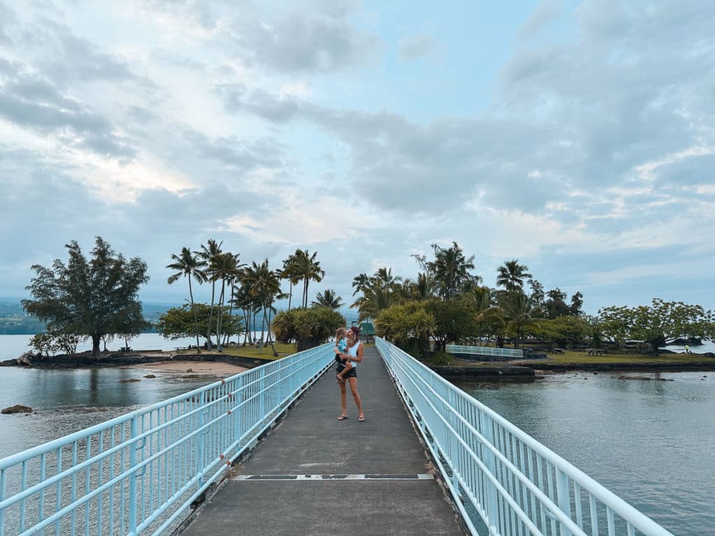 A Mom holding her kid on the footbridge of Coconut Island in Hilo, Big Island, Hawaii