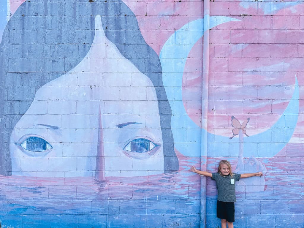A boy posing in front of a mural in downtown Hilo on the Big Island of Hawaii