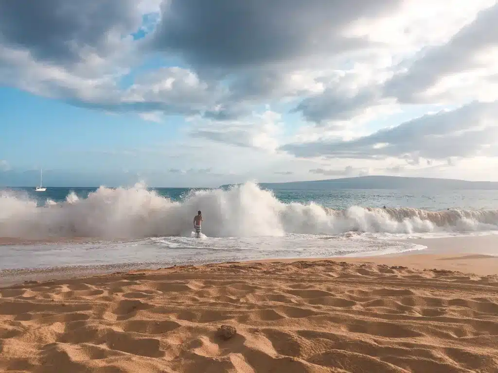 A man enters a massive wave on Big Beach, Maui, Hawaii. 