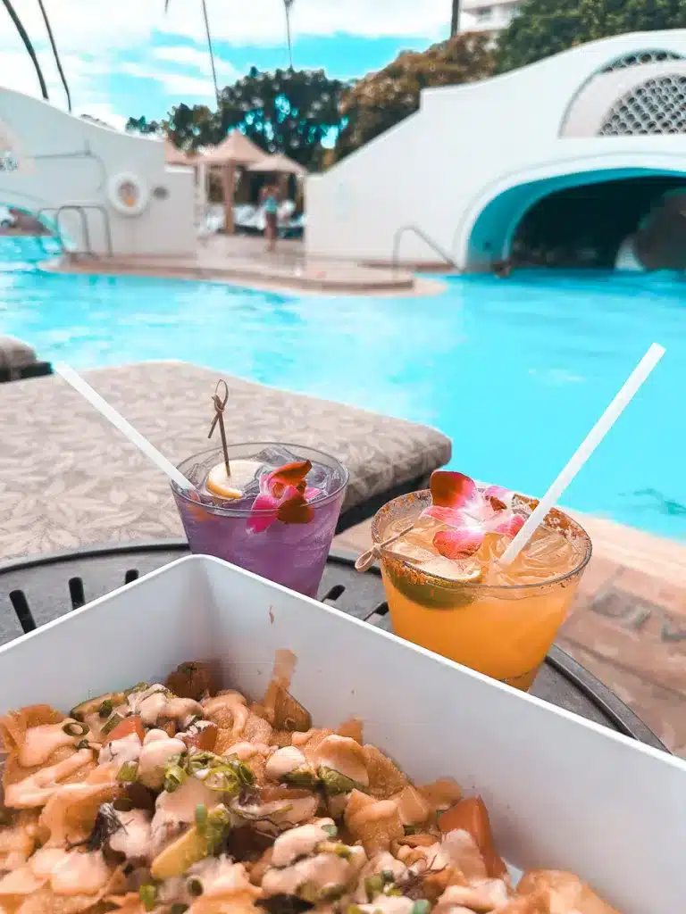 Two tropical drinks and a platter. of poke nachos at the pool in Fairmont Kea Lani.