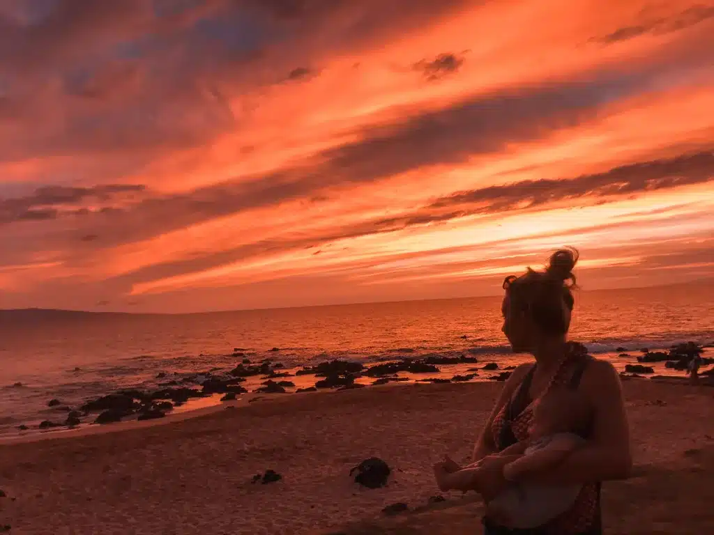 A mom and baby gaze at a jaw-dropping sunset in Maui, Hawaii.  