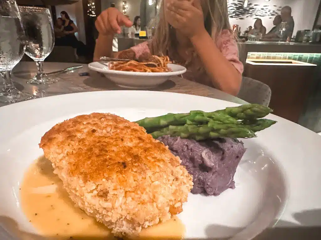 A plate of crusted mahi mahi, smashed purple sweet potatoes, and asparagus at Nick's Seafood Restaurant in Maui, Hawaii.