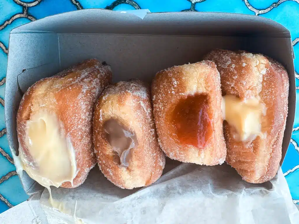 Four Malasadas in a box from Tex Drive In on the Big Island of Hawaii.