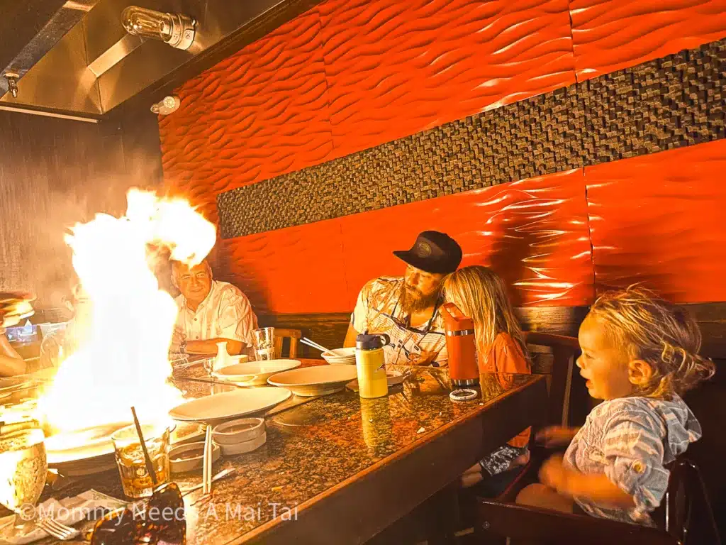 A family watches a large flame on the grill at a Japanese Steakhouse at Hilton Hawaiian Village in Waikiki, Oahu, Hawaii. 