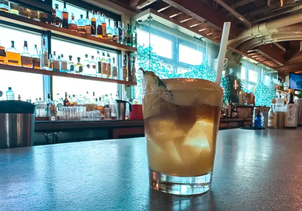 A world famous mai tai with lilikoi foam on top sitting on the bar at Monkey Pod Kitchen in Hawaii. 