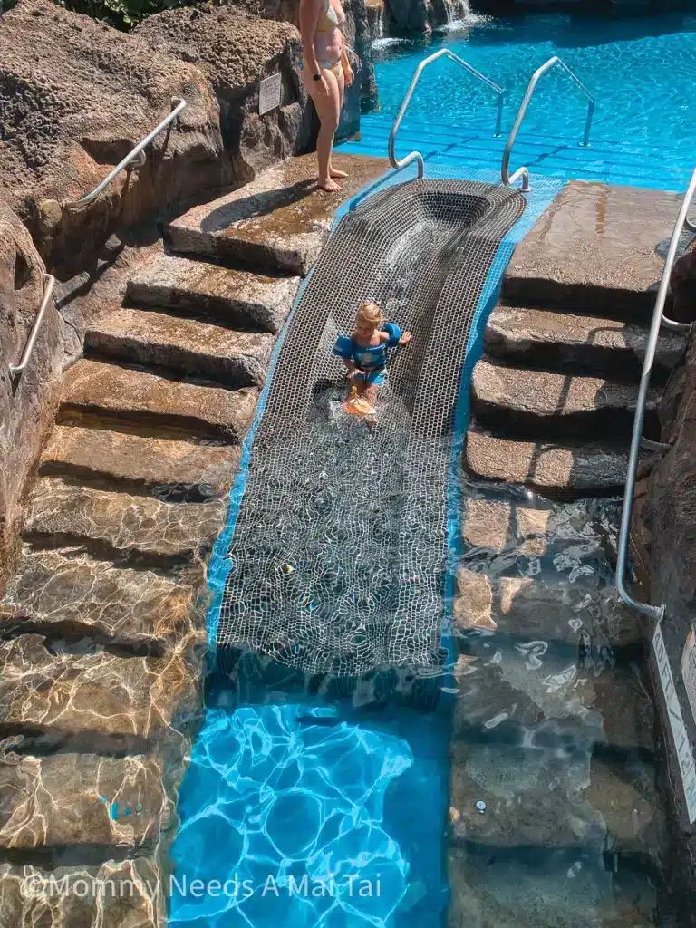 A kid going down a small waterslide at the Sheraton Resort on Maui, Hawaii. 