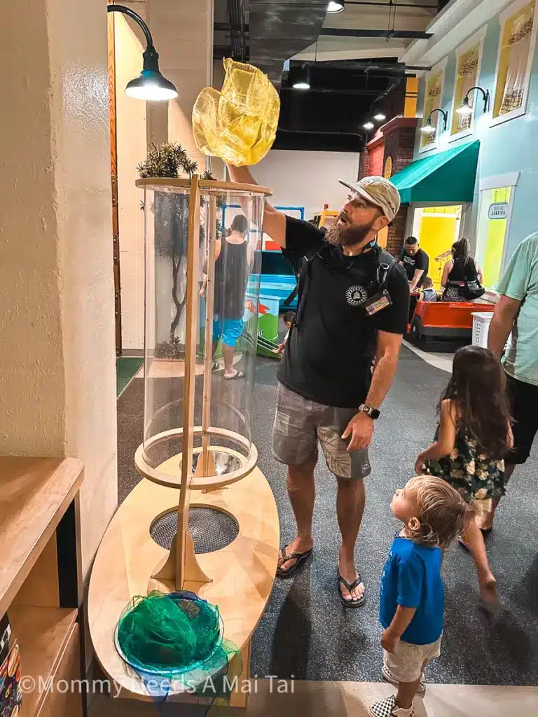 A dad standing in front of a science exhibit at the Children's Discovery Museum in Oahu, Hawaii.